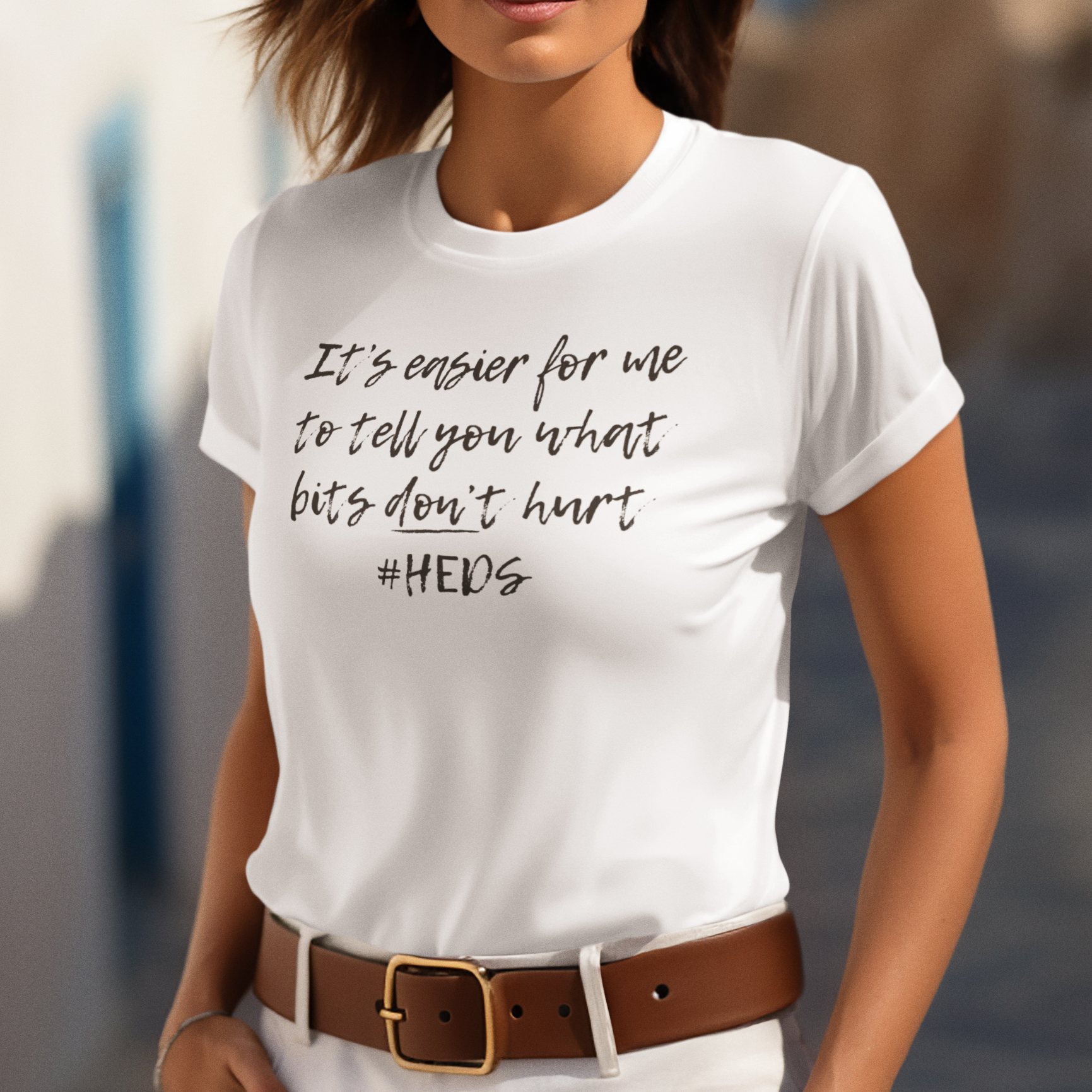 A person wearing the relaxed-fit "It Is Easier To Tell You What Bits Don't Hurt" tee. Soft, non-restrictive apparel designed for Spoonies who need maximum comfort when navigating widespread pain.